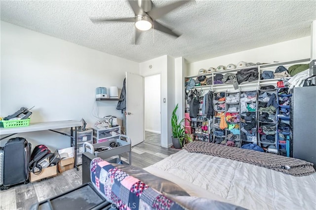 bedroom with ceiling fan, a textured ceiling, and wood finished floors