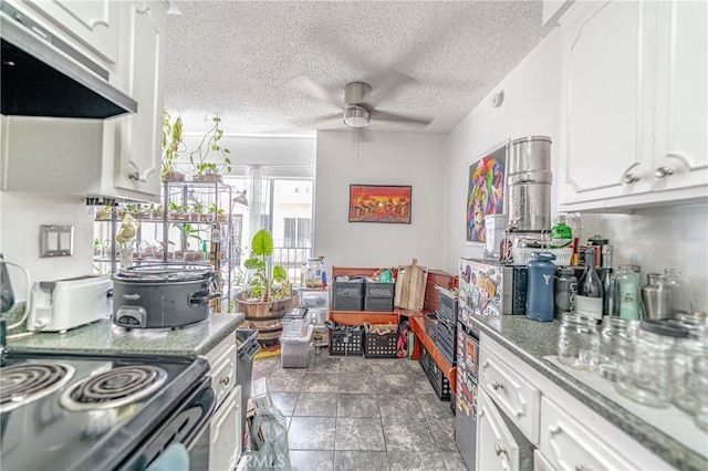 kitchen with a ceiling fan, white cabinets, and a textured ceiling