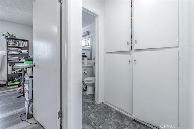 bathroom with toilet and a textured ceiling