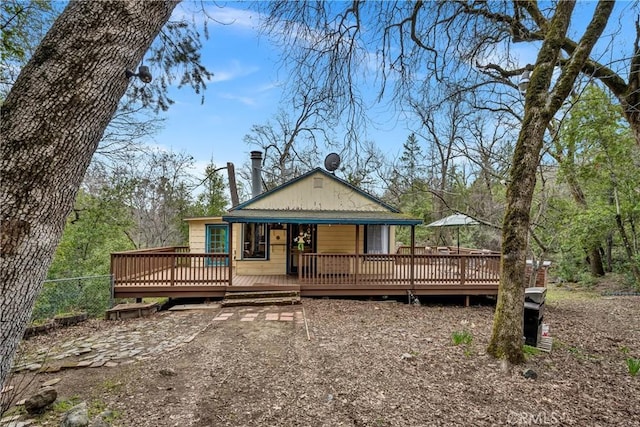 rear view of property featuring fence and a wooden deck