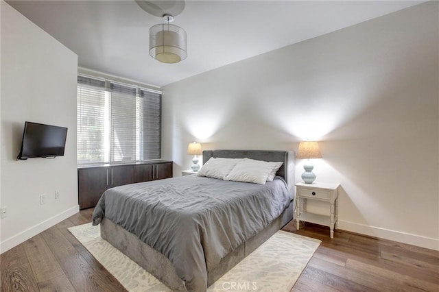 bedroom featuring baseboards and wood finished floors