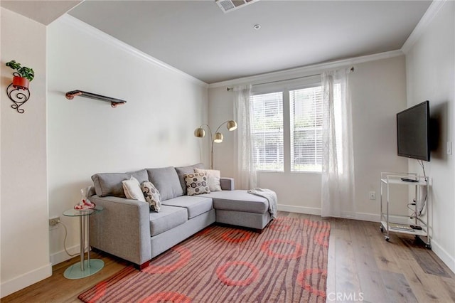 living room featuring light wood-style floors, visible vents, ornamental molding, and baseboards