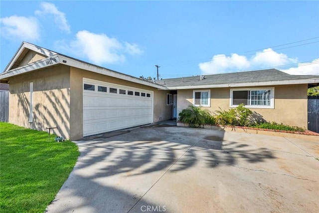 ranch-style home with an attached garage, driveway, a front yard, and stucco siding