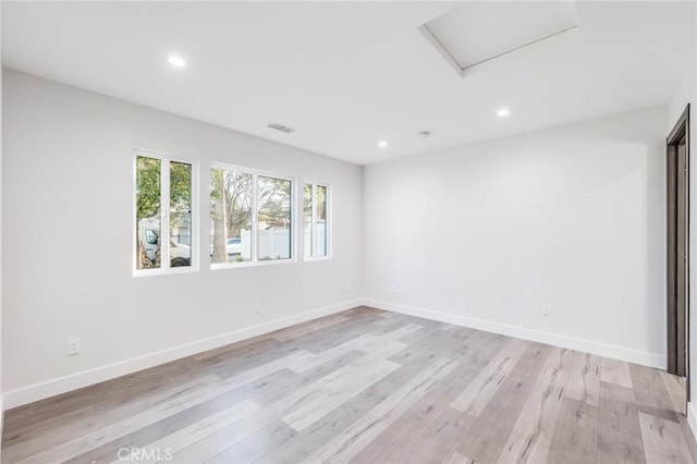 spare room featuring visible vents, recessed lighting, light wood finished floors, baseboards, and attic access