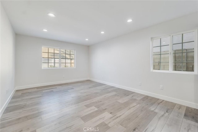 unfurnished room featuring recessed lighting, light wood-style floors, and baseboards