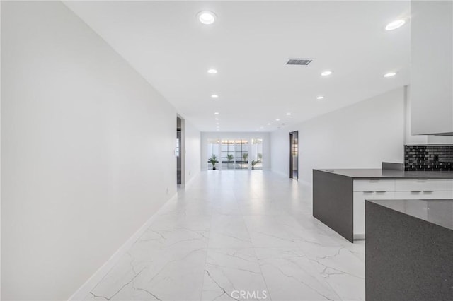 hallway with recessed lighting, visible vents, baseboards, and marble finish floor