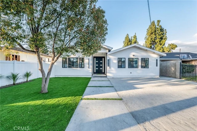 single story home with stucco siding, a front yard, and fence