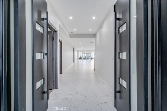 hallway with recessed lighting, baseboards, and marble finish floor