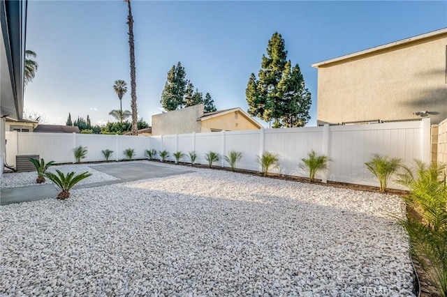 view of yard with a patio area, central air condition unit, and a fenced backyard