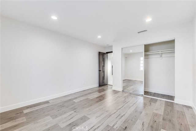 unfurnished bedroom with visible vents, baseboards, recessed lighting, light wood-style floors, and a closet