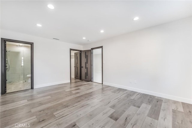 unfurnished bedroom featuring ensuite bathroom, recessed lighting, baseboards, and light wood finished floors