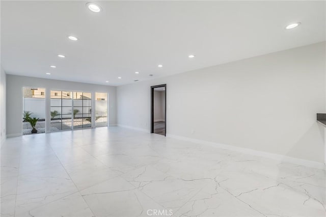 empty room with recessed lighting, baseboards, and marble finish floor