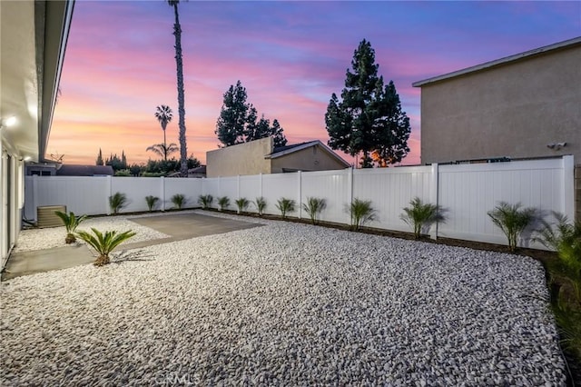 yard at dusk featuring a patio and a fenced backyard