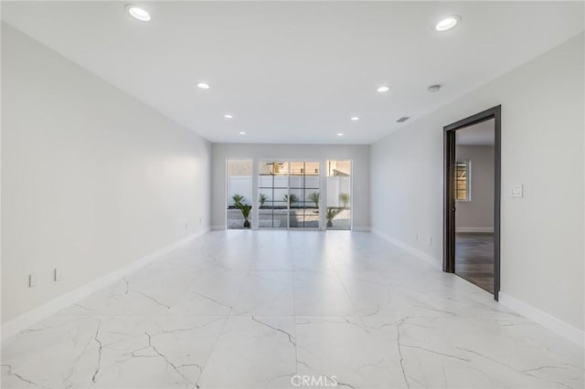 empty room with recessed lighting, baseboards, and marble finish floor