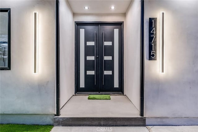 entrance to property featuring stucco siding