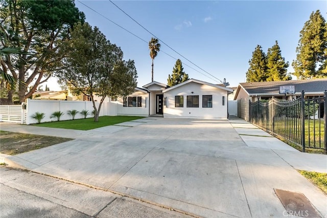 ranch-style home featuring a front yard, fence, and stucco siding