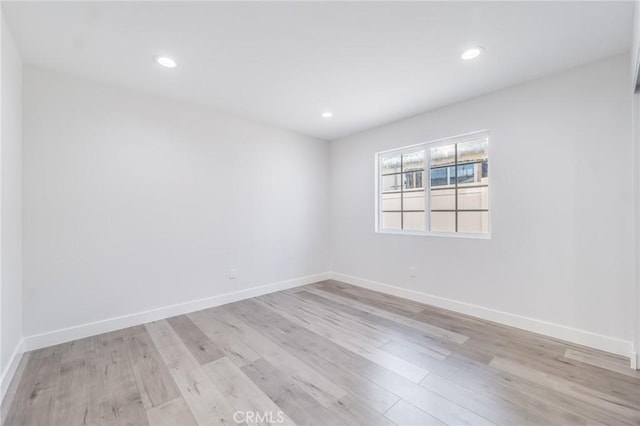 unfurnished room featuring light wood finished floors, recessed lighting, and baseboards