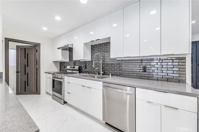 kitchen with a sink, modern cabinets, marble finish floor, and stainless steel appliances