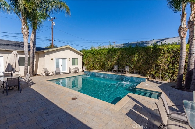 outdoor pool featuring an outbuilding, a patio, a storage structure, and french doors