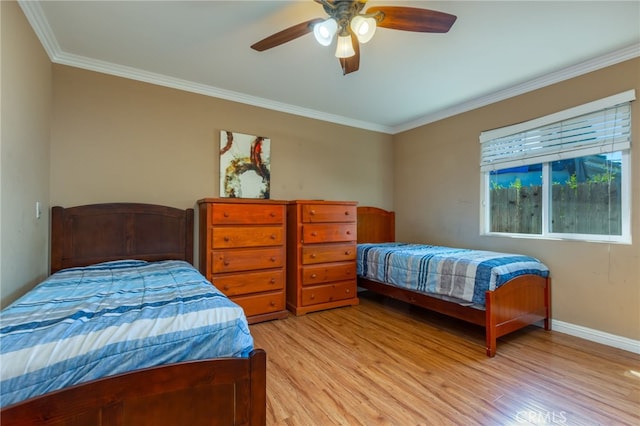 bedroom featuring baseboards, ceiling fan, light wood finished floors, and crown molding