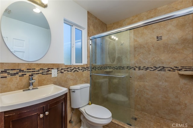 bathroom featuring a stall shower, tile walls, toilet, and vanity