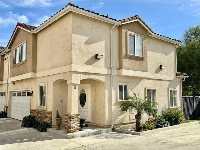 multi unit property with stone siding, a tiled roof, an attached garage, and stucco siding