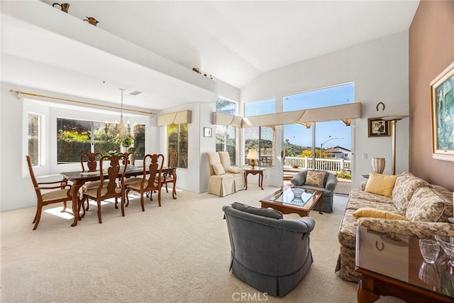 carpeted living area featuring lofted ceiling, visible vents, and a chandelier