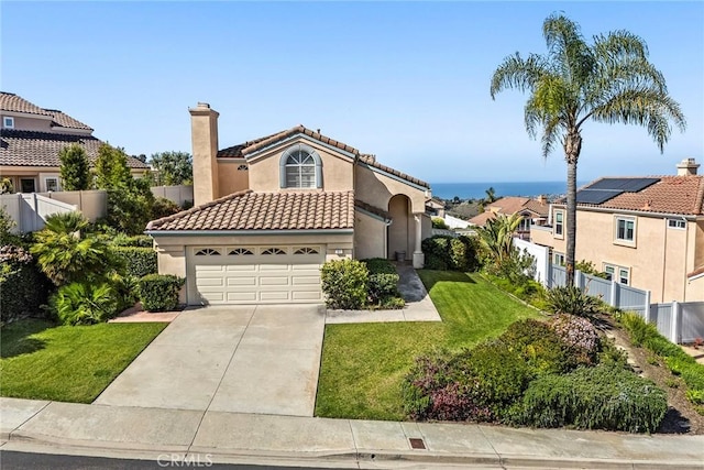 mediterranean / spanish-style house featuring stucco siding, an attached garage, fence, driveway, and a front lawn