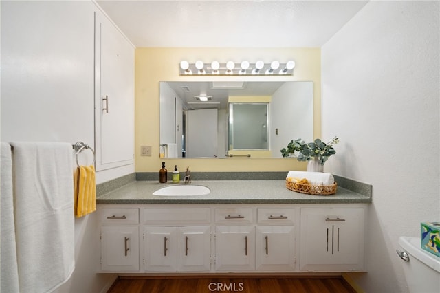 bathroom featuring toilet, wood finished floors, and vanity