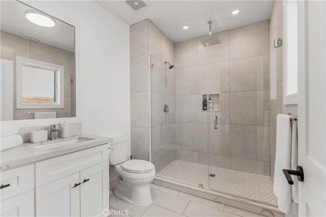 full bath featuring tile patterned flooring, a shower stall, toilet, and vanity