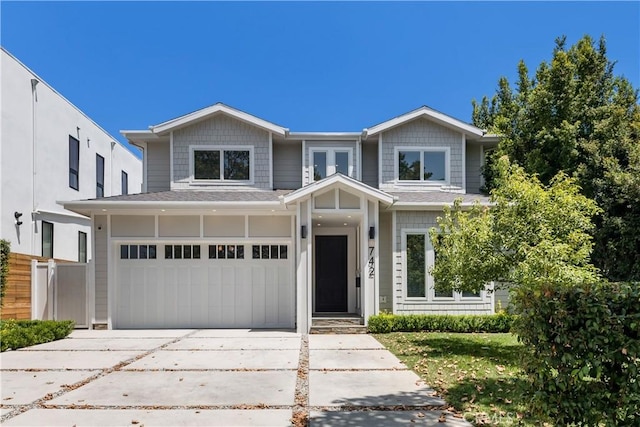 view of front facade featuring concrete driveway, fence, and an attached garage