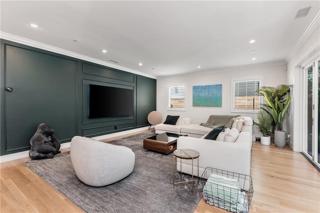 living room featuring light wood finished floors, visible vents, crown molding, and recessed lighting