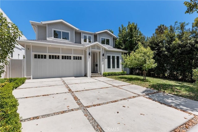 view of front of home with driveway, a front lawn, an attached garage, and fence