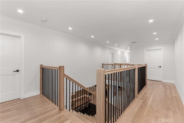 hallway featuring light wood-type flooring, an upstairs landing, and recessed lighting