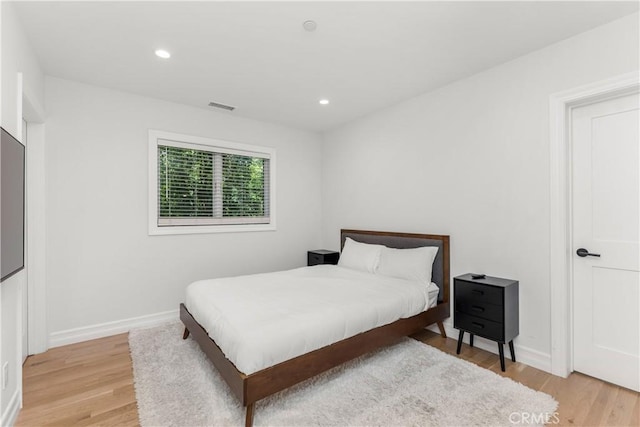 bedroom featuring baseboards, light wood finished floors, visible vents, and recessed lighting