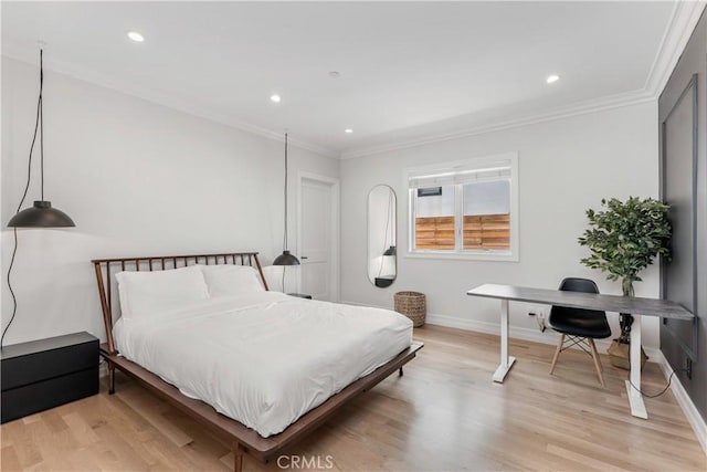 bedroom featuring baseboards, crown molding, and light wood finished floors