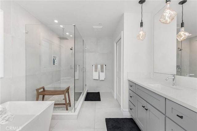 full bath featuring a freestanding tub, tile patterned flooring, vanity, tile walls, and a shower stall