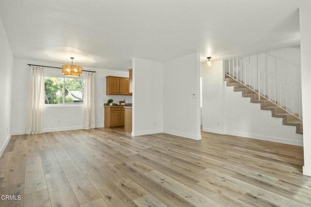 138 S Bryn Mawr St Unit 40, Ventura, CA 93003 - unfurnished living room featuring light wood finished floors and stairs