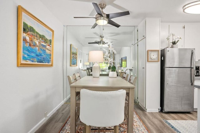 dining area with ceiling fan, baseboards, and wood finished floors