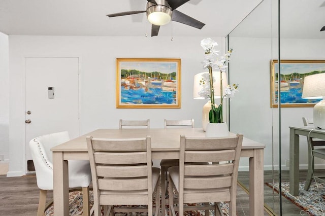 dining space featuring ceiling fan, wood finished floors, and baseboards