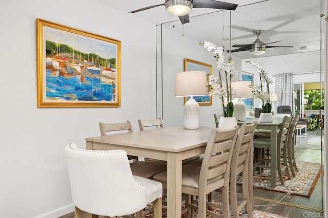 dining area with baseboards, a ceiling fan, and wood finished floors