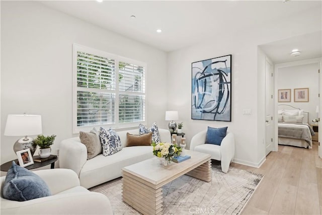 living area featuring light wood-type flooring, baseboards, and recessed lighting