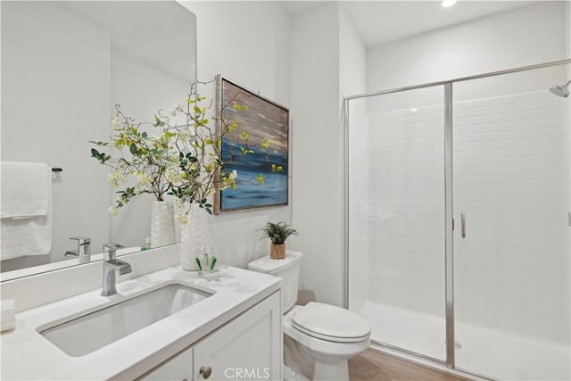 bathroom featuring a stall shower, vanity, and toilet