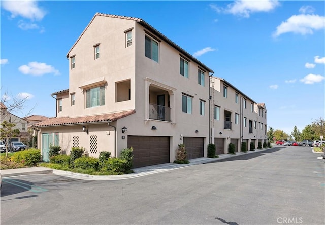 view of building exterior featuring a garage and a residential view