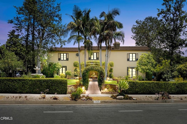 mediterranean / spanish-style house with stucco siding and a tiled roof