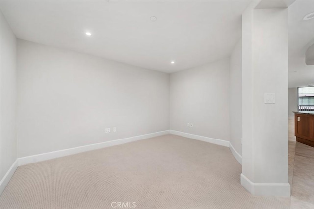 unfurnished room featuring recessed lighting, light carpet, and baseboards