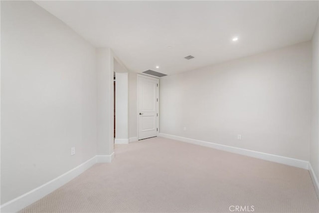 spare room with recessed lighting, light carpet, visible vents, and baseboards