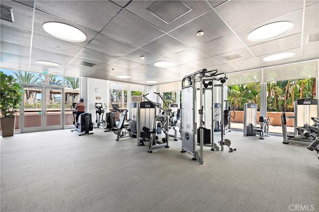 gym featuring a paneled ceiling, french doors, carpet flooring, and visible vents