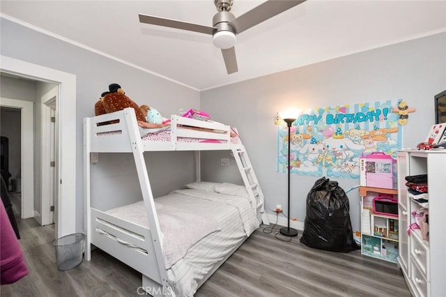 bedroom with ceiling fan, wood finished floors, and crown molding