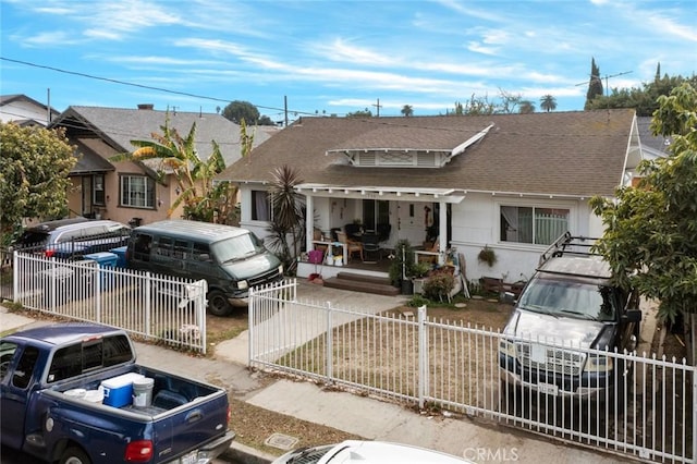 view of front of home featuring a fenced front yard and roof with shingles